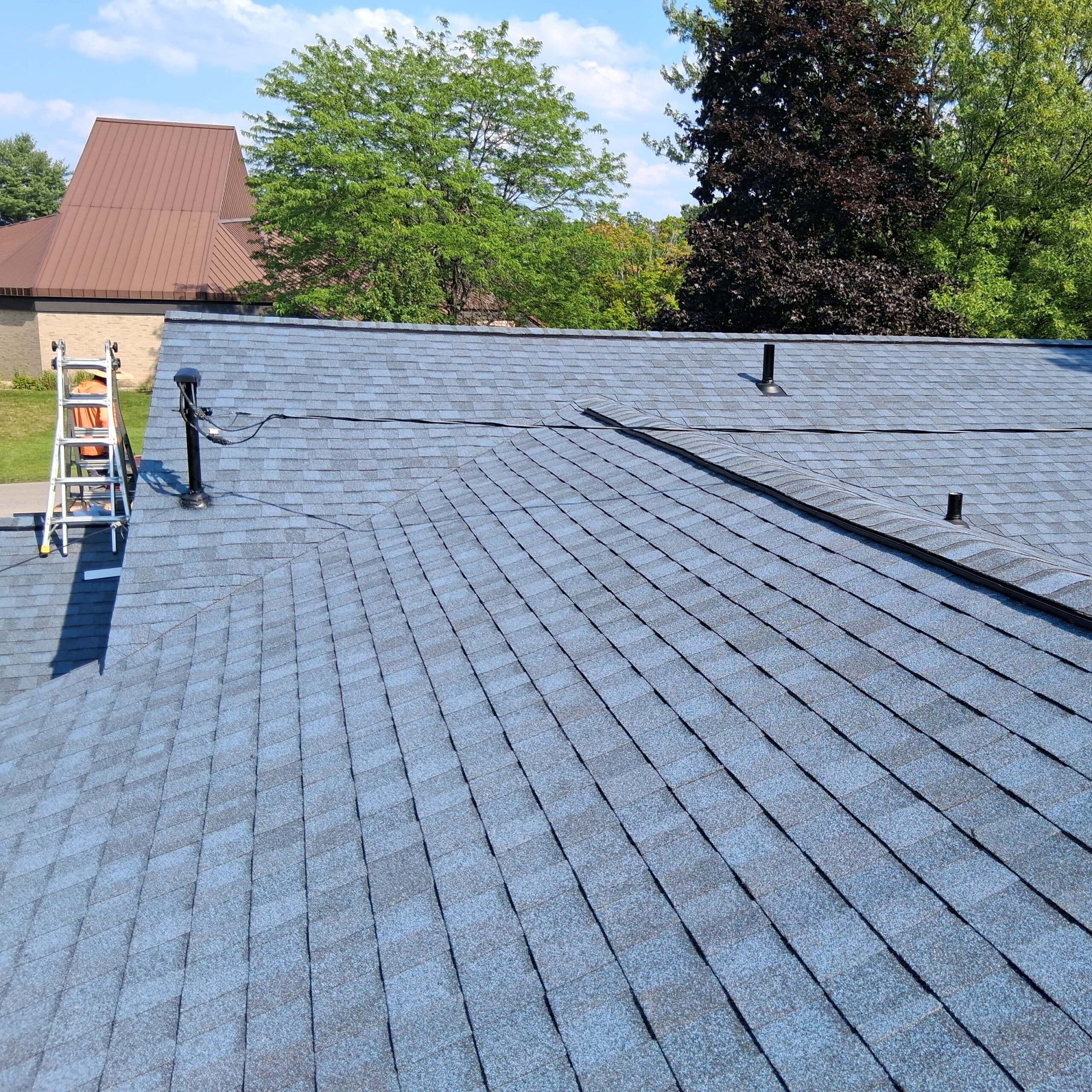 roofing contractor traverse city mi — blue asphalt shingle installation