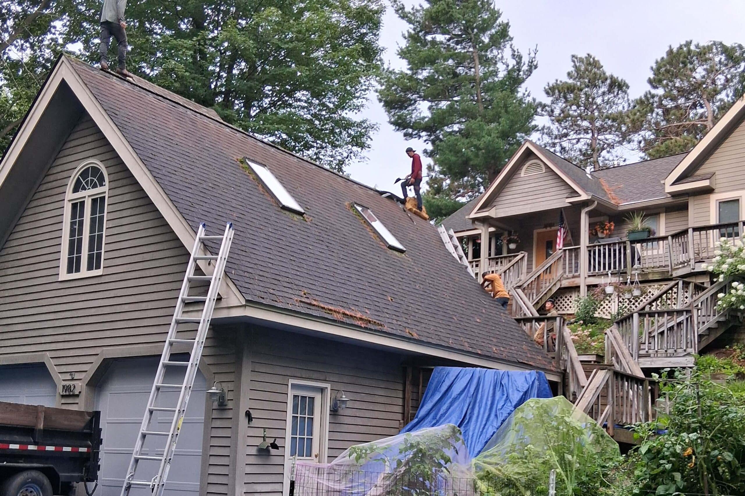 roofing contractor cadillac mi — workers on steep residential roof